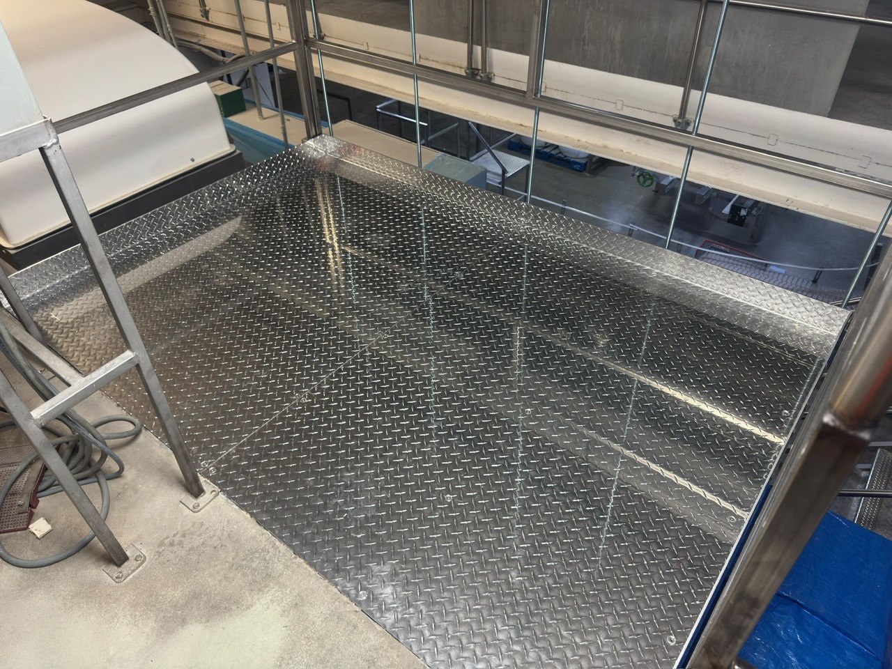 Diamond plate decking on a retrofitted conveyor access platform, GTA industrial facility